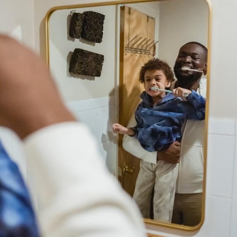 father and son brushing teeth together
